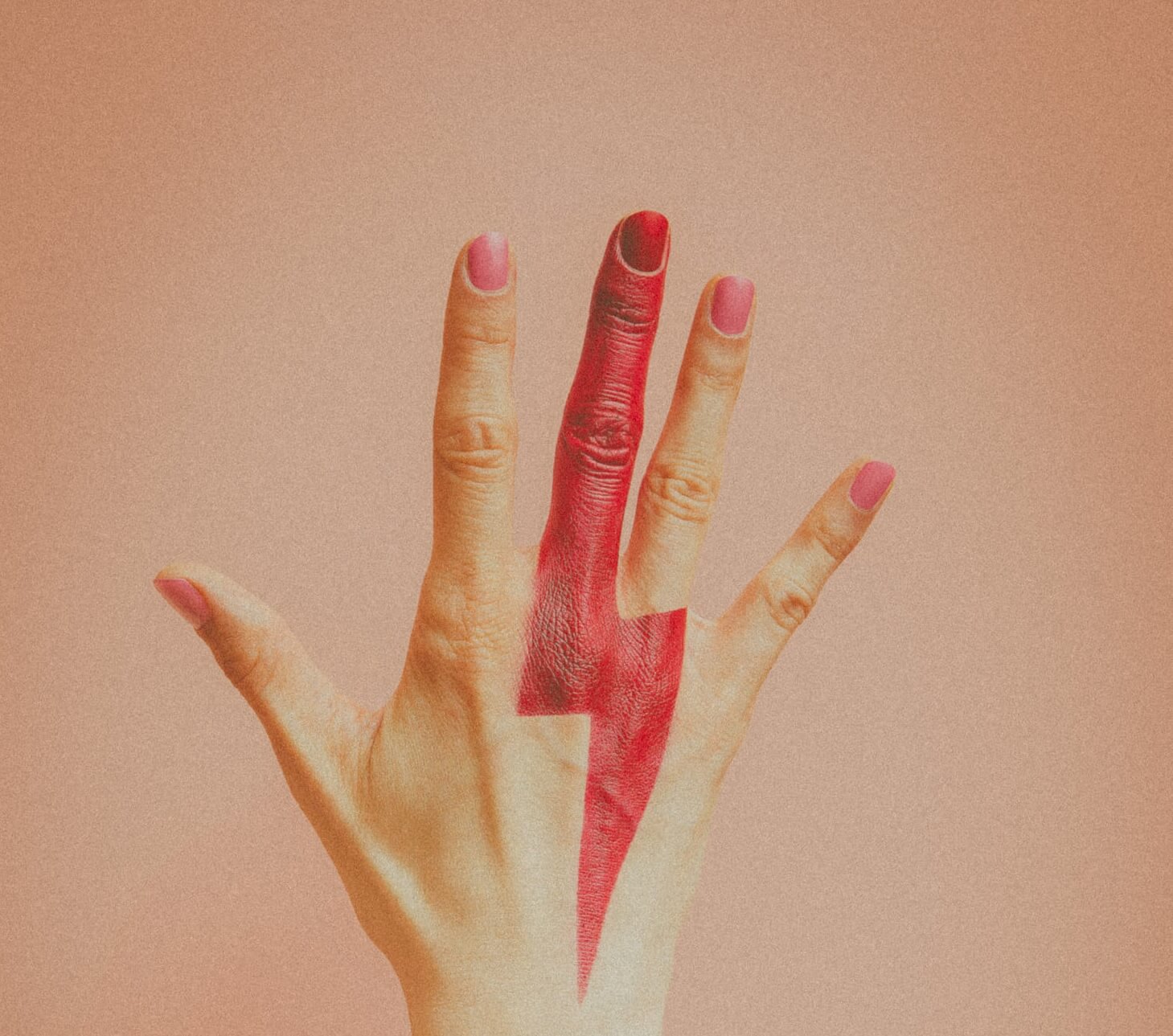 A woman's hand with a pink thunderbolt painted on it