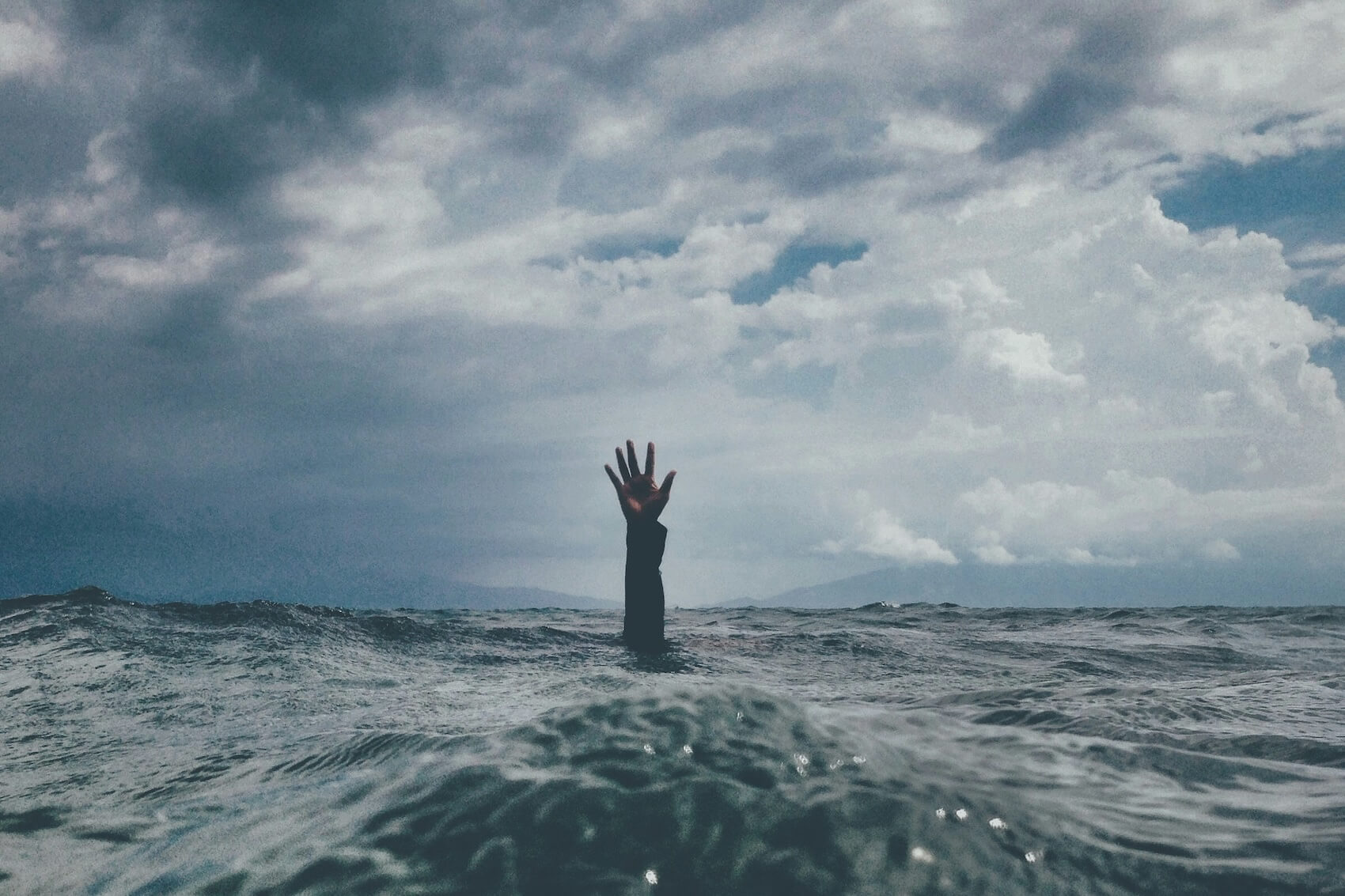 A hand pokes out of the water.