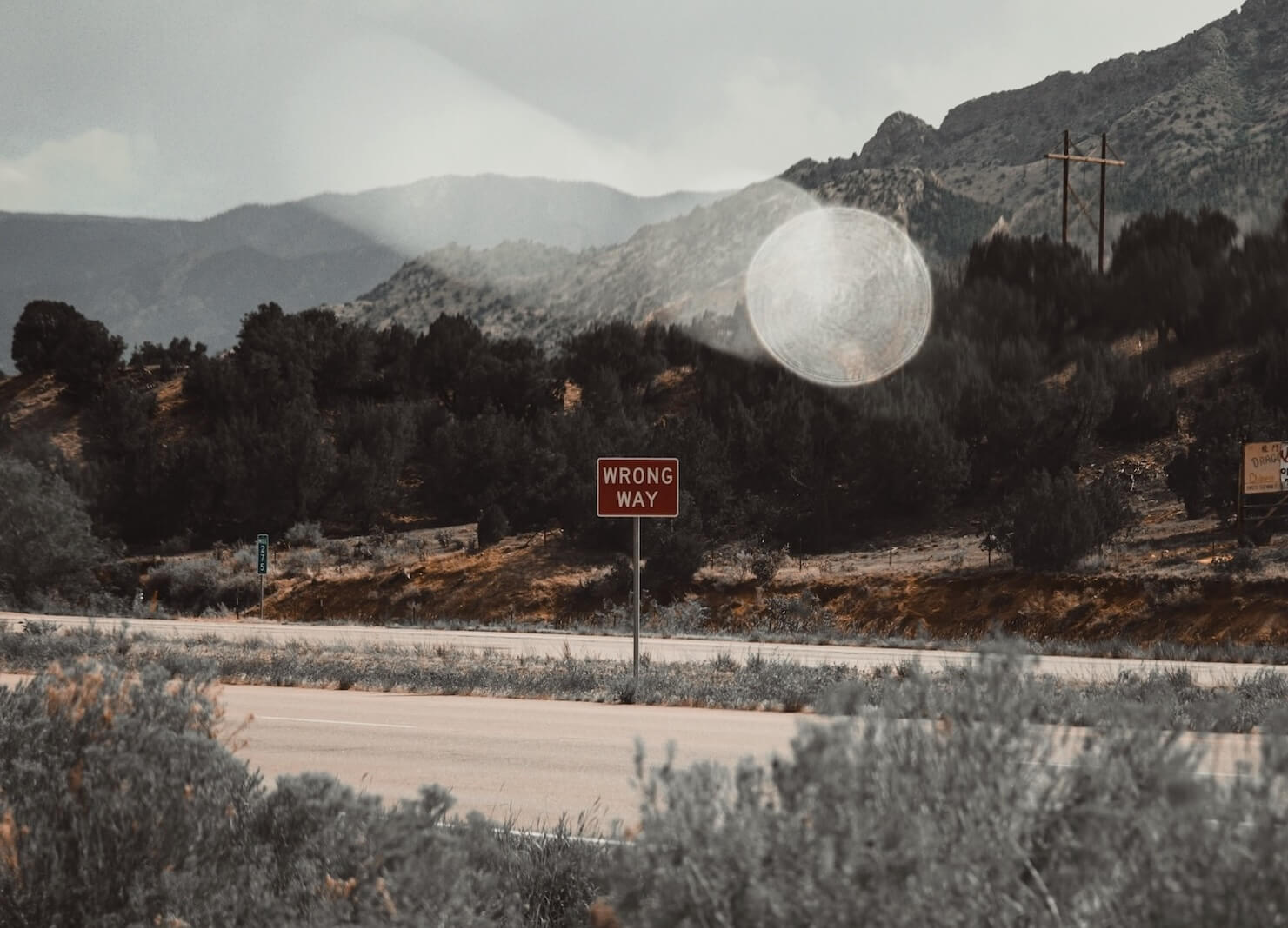 A sign says "wrong way" as a vehicle makes a blurry journey though the desert.