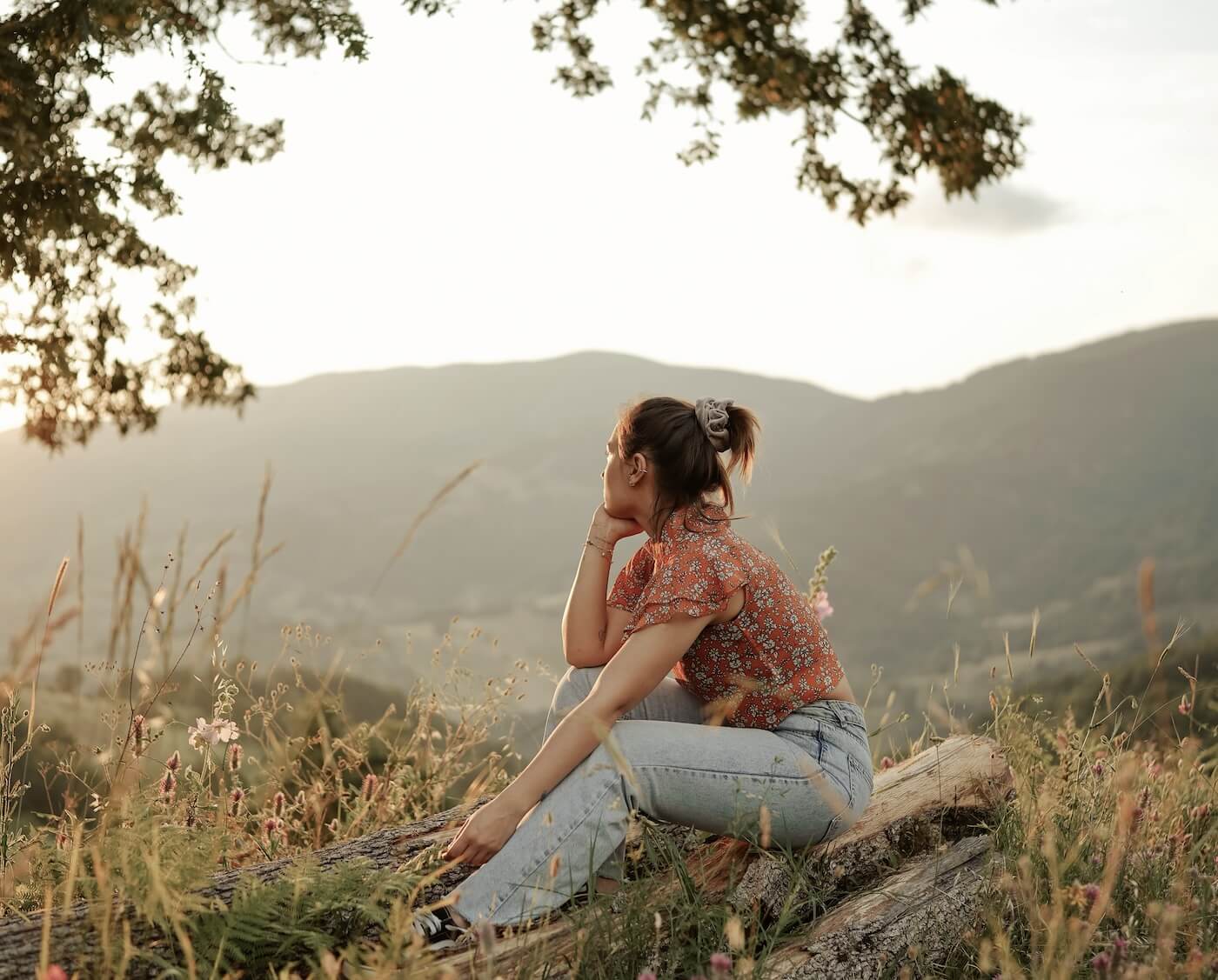 A woman stars over a hill lost in her thoughts.